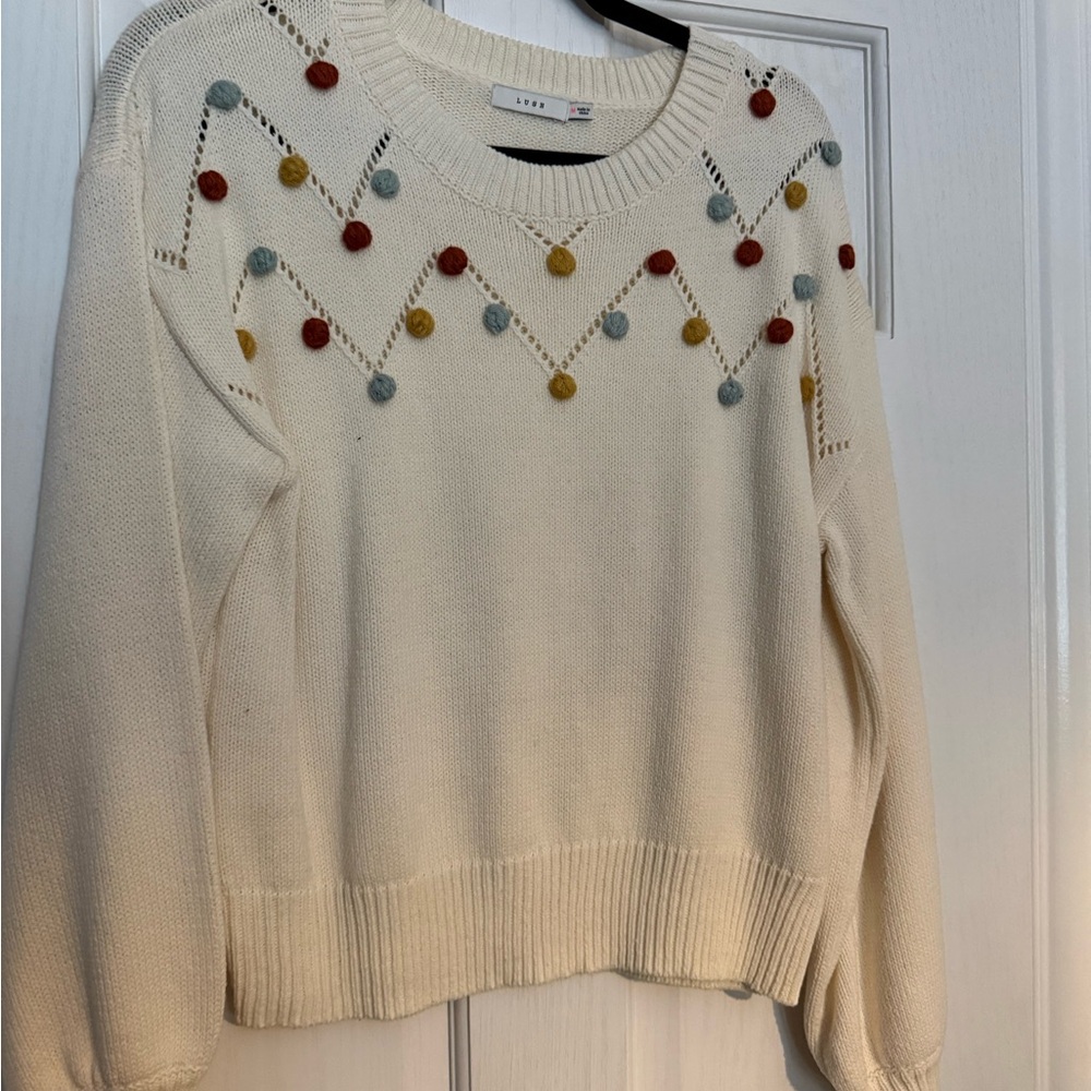 Lush Cream Sweater with Red, Yellow, and Blue Accents